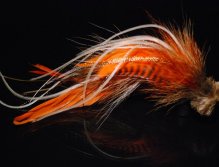 This is a combination of brown and orange schlappen mixed with tan bucktail and with  microbarb saddles with a tightly packed tan deer hair head