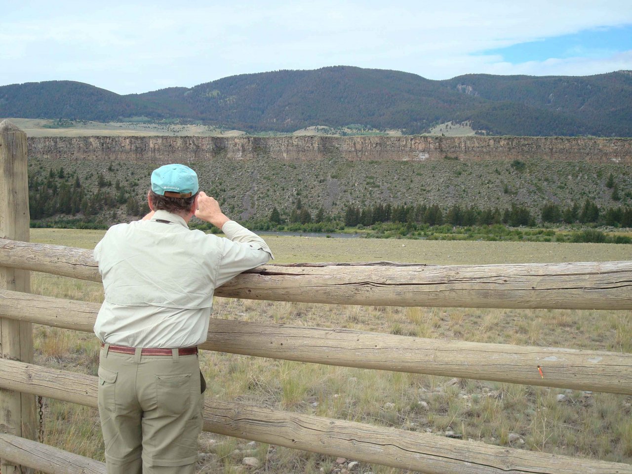 Fisherman looks across the Madison at the Palisades , where Blackfeet Indians used to drive herds of bison over the cliffs