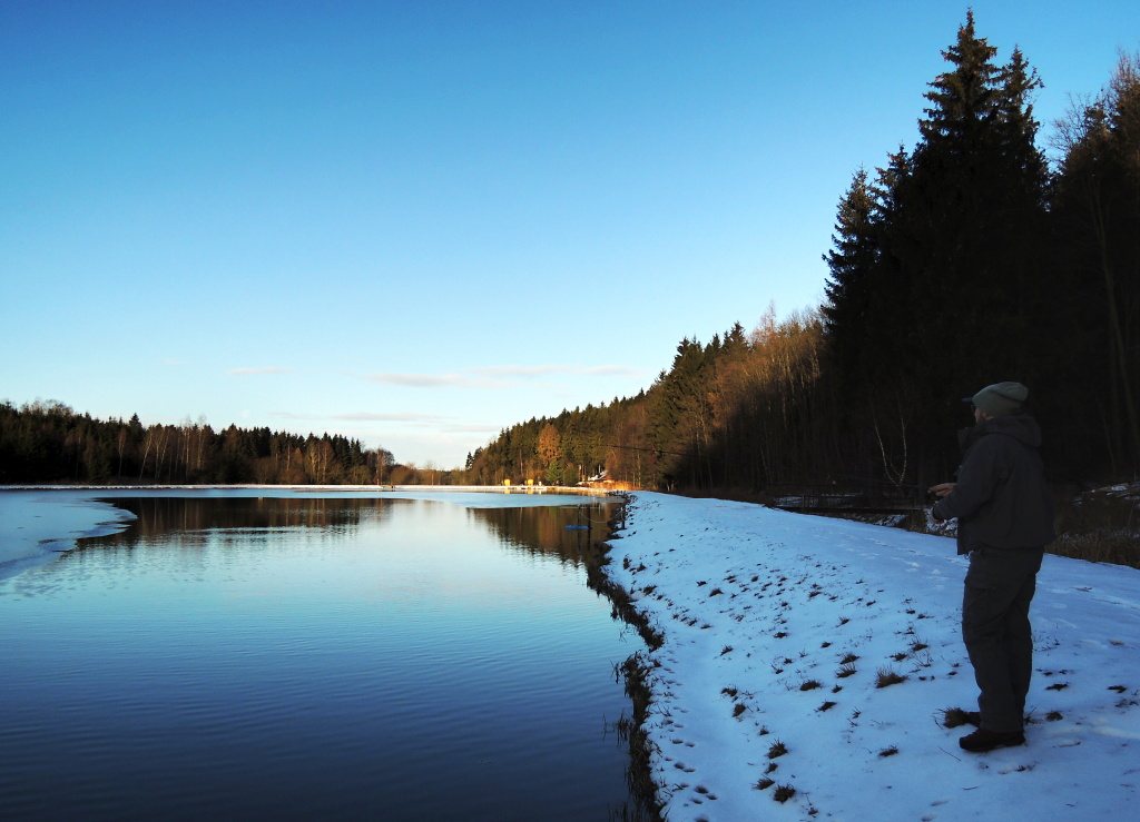 In this photo is shown all the above. A well and warmly dressed fisherman in quality footwear that protects his feet from the cold of the frozen ground, fishing tactically along the icy edge for the fish that hide under the icy water surface!